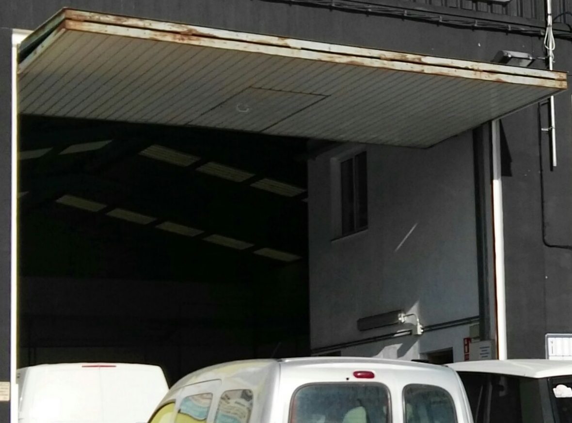 Portón de la nave abierto, con el taller al fondo